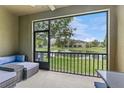 Screened-in patio with outdoor seating overlooking a serene pond and manicured lawn at 5153 Bay Isle Cir, Clearwater, FL 33760