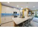 Modern kitchen with stainless steel appliances, quartz countertops, and a breakfast bar at 6031 Grand Sonata Ave, Lutz, FL 33558