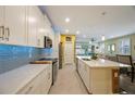 Well-lit kitchen with stainless steel appliances, an island and seamless flow to dining and living areas at 6031 Grand Sonata Ave, Lutz, FL 33558