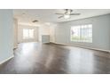 Spacious living room with natural light, complemented by dark wood-look floors at 7410 E Bank Dr, Tampa, FL 33617