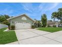 Side view of a single-story home featuring a two-car garage, landscaped lawn, and a glimpse of the backyard at 8549 Pinafore Dr, New Port Richey, FL 34653