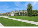 Side view of a single-story home featuring manicured lawn, and trimmed bushes at 8549 Pinafore Dr, New Port Richey, FL 34653