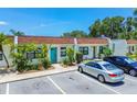 Townhome exterior with assigned parking, well-maintained landscaping, and a bright turquoise front door at 9142 Oakwood Ln, Seminole, FL 33776