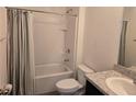Well-lit bathroom featuring a shower-tub combo, tile surround, and modern fixtures and toilet at 9724 Troncais Cir, Thonotosassa, FL 33592