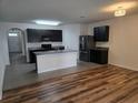 Modern kitchen featuring stainless steel appliances, granite countertops, and stylish cabinetry with a view to the living area at 9724 Troncais Cir, Thonotosassa, FL 33592