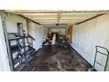 Attached garage space showing interior with empty walls and damaged ceiling at 1107 Goshen Rd, Tarpon Springs, FL 34689