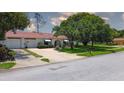 Beautiful one-story home with a red tile roof, arched entryway, and lush green lawn at 11334 Winwood Pl # 11334, Port Richey, FL 34668