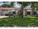 Well-maintained lawn leads to this lovely home with awnings and mature landscaping at 11334 Winwood Pl # 11334, Port Richey, FL 34668