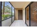 Cozy screened balcony with tile flooring, offers a private space for relaxing outdoors at 11805 Raintree Lake Ln # A, Tampa, FL 33617