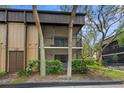 Condo exterior showcasing private screened balconies and well-maintained grounds, shaded by mature trees at 11805 Raintree Lake Ln # A, Tampa, FL 33617