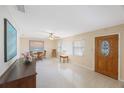 Bright living room featuring speckled floors, a ceiling fan, and an ornate wood front door at 1305 Marion S Dr, St Petersburg, FL 33707
