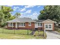 Classic brick home with mature trees offers a welcoming curb appeal and traditional design elements at 1511 East Emma St. E St, Tampa, FL 33610