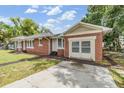 A classic brick home with a driveway and a well-maintained lawn showing a traditional architectural style at 1511 East Emma St. E St, Tampa, FL 33610