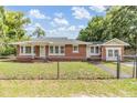 Quaint single-Gathering brick home surrounded by a chain link fence at 1511 Emma E St, Tampa, FL 33610