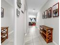 Inviting hallway with tile flooring, decorative wall art, and a glimpse of the cozy living room at the end at 17136 Sunshine Mimosa: St, Wimauma, FL 33598