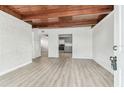 Bright living room with wood beam ceiling, freshly painted walls, and modern wood-look floors at 1807 E Bougainvillea Ave, Tampa, FL 33612