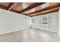 Bright living room with wood beam ceiling, freshly painted walls, and modern wood-look floors at 1807 E Bougainvillea Ave, Tampa, FL 33612