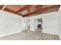 Bright living room with wood beam ceiling, freshly painted walls, and modern wood-look floors at 1807 E Bougainvillea Ave, Tampa, FL 33612