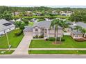 Beautiful two-story home with a well-manicured lawn, palm trees, and a long driveway at 18219 Bittern Ave, Lutz, FL 33558