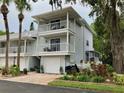 Two-story condo with dual balconies, a garage, lush landscaping and brick paver driveway at 2015 Vista Del Sol # 108, Lutz, FL 33558