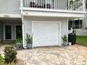 Single-car garage with paved driveway and lush landscaping enhancing curb appeal at 2015 Vista Del Sol # 108, Lutz, FL 33558