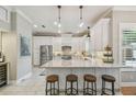 Bright kitchen featuring a large island with seating, granite countertops, stainless steel appliances, and custom cabinetry at 2522 W Watrous Ave, Tampa, FL 33629