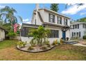 A charming home with an American flag, lush landscaping, and a bright blue door at 310 N Lincoln Ave, Clearwater, FL 33755