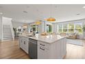 Bright, open-concept kitchen featuring a large island, stainless steel appliances, and modern pendant lighting at 3541 Great Banyan Way, Wesley Chapel, FL 33543