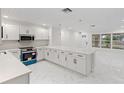 Modern kitchen boasting white cabinets, quartz countertops, stainless steel appliances, and open-concept design at 3552 Middletown St, Port Charlotte, FL 33952