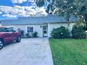 Home exterior with a concrete driveway, flowering shrubbery and healthy green lawn at 3725 Teeside Dr, New Port Richey, FL 34655