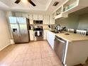 Well-lit kitchen with stainless steel appliances, white cabinets, and tiled floor at 3725 Teeside Dr, New Port Richey, FL 34655