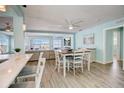 Bright, open-concept dining area with light wood floors, a modern table, and picturesque water views at 500 20Th Ave, Indian Rocks Beach, FL 33785