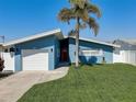 Charming single-story home with vibrant blue siding, well-manicured lawn, and a one-car garage at 500 20Th Ave, Indian Rocks Beach, FL 33785
