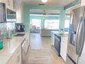 Stylish kitchen with stainless steel appliances, white cabinetry, and an open view to the living area at 500 20Th Ave, Indian Rocks Beach, FL 33785