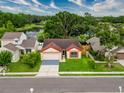 Charming single-story home featuring a two-car garage and well-maintained landscaping near a pond at 5016 Cypress Trace Dr, Tampa, FL 33624