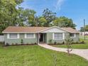 A single-story home with a brick walkway, green lawn, and neat landscaping at 5053 18Th St, Zephyrhills, FL 33542