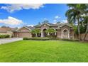 Charming home features a well-manicured lawn, mature landscaping and a double-door entryway, creating a welcoming curb appeal at 512 Creekside Ct, Safety Harbor, FL 34695