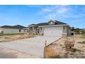 New construction showcasing a two car garage, a concrete driveway, and a well-manicured lawn at 5441 Chestnut Ridge Rd, Dade City, FL 33523