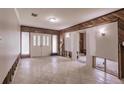 Bright living room with tile flooring, wood paneling, and a double door entrance at 647 74Th N Ave, St Petersburg, FL 33702