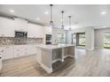 Open kitchen with white cabinets, quartz countertops, stainless steel appliances, and center island at 7276 Notched Pine Bnd, Wesley Chapel, FL 33545