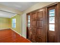 Interior entryway featuring wood flooring and a stained wood door with decorative glass inserts at 7309 Monterey Blvd, Tampa, FL 33625