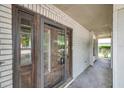 Front entryway with dark wood door, brick surround, and partial view of manicured landscaping at 7309 Monterey Blvd, Tampa, FL 33625
