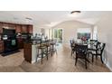 Open kitchen and dining area with tile floors, dark cabinets, and access to the backyard at 8524 Winter Haven Dr, Hudson, FL 34667