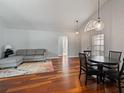 Open-concept living room featuring hardwood floors, gray sofa, dining area, and ample natural light at 9008 Egret Cove Cir, Riverview, FL 33578