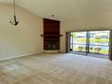 Spacious living room with a fireplace, lake views, and sliding glass doors to the lanai at 907 San Carlos Ne Ave, St Petersburg, FL 33702