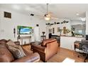 Bright living room with hard wood floors, ceiling fan, and view to kitchen with bar top at 10401 Lakeside Vista Dr, Riverview, FL 33569