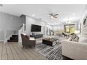 Bright and airy living room with tile floors, modern furnishings, and seamless access to the kitchen and dining area at 11526 Crowned Sparrow Ln, Tampa, FL 33626