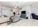 Bright living room featuring tile floors, comfortable seating, and entertainment center at 1162 Music Ln, North Port, FL 34286