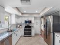 Modern kitchen featuring stainless steel appliances, granite counters, and white cabinets at 12920 124Th Ave, Largo, FL 33774