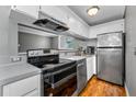 Well-lit kitchen equipped with stainless steel appliances, sleek countertops, and ample cabinet space with hardwood floors at 1301 S Howard Ave # A22, Tampa, FL 33606